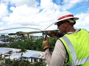 Delta Company's Cpl. David Schmidt repairs an electric line that powers water wells in the Gualo Rai area of Saipan. (Contributed Photo)