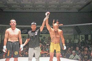 Frank “The Crank” Camacho, right, is declared the winner by referee Alverick Alvarez, center, following his first-round stoppage of Yasuaki Miura of Zendokai Nagano in Rites of Passage 18: Warpath last July 3 at the Royal Taga Hall of the Saipan World Resort. (Jon Perez)