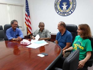 Gov. Eloy S. Inos sits with education leaders and a lawmaker at the signing of a bill to allow for the election of a teacher representative on the Board of Education. From left, are Sen. Justo Quitugua, Inos, Education Board chair Herman Guerrero, and Education Board member Denise King. (Dennis B. Chan)