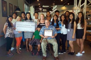 Delegate Gregorio Kilili C. Sablan, seated center, and his wife, Andrea, are presented with a plaque of appreciation by members of the United 4 Saipan volunteer group on Thursday. Others in photo are Medilda David, Eloise Rose E. Lopez, Maria Lumauag, Parsley Linaogo, Stephanie Gruy, Chelsea Cayabyab, Farley Rey Orcajo Linaogo, Jeffrey Quilala, Mharbin David, Jenny Hegland, Nola Hix, Ballen Song, Sarka Glaschova, and Grace Orcajo, (Contributed Photo)
