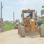 Hawaiian Rock employees, followed by Department of Public Works employees, get ready to pave a portion of Pine Drive and a portion of Pepega Avenue near Tank Beach. (Jayson Camacho) 