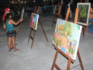 A couple looks at the artwork submitted during last year’s arts competition in the 2016 Flame Tree Arts Festival at the Civic Center in Susupe. (JON PEREZ)