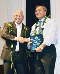 Triple J Saipan's vice president for finance and administration Michael S. Sablan, right, receives a congratulatory handshake from businessman Joe Ayuyu after being named as the Saipan Chamber of Commerce's 2016 Business Person of the Year in last Saturday's ceremony at Fiesta Resort & Spa's Hibiscus Hall. (Jon Perez)