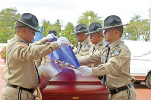 Department of Public Safety officers fold the CNMI flag as the remains of the late Northern Islands mayor Jerome K. Aldan is about the be wheeled in to the Mt. Carmel Cathedral in Chalan Kanoa. (Jon Perez)
