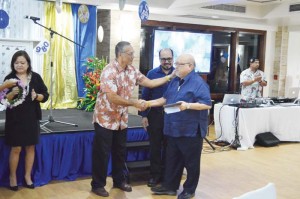 2017 AlumKnight of the year Jesus “JM” Guerrero shakes hands with AlumKnight Association president Charles Cepeda as Mount Carmel School president Galvin Deleon Guerrero looks on after the presentation of the plaque. (Erwin Encinares)