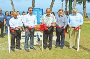 Bridge Capital LLC chief operating officer Jody Jordahl, second from left, Saipan Mayor David Apatang, center, and Bridge Capital LLC chief financial officer Clay Crawford, far right, cut the ribbon to announe that the Gov. Froilan C. Tenorio Beach Road Pathway workout stations are now ready for public use. (Erwin Encinares)