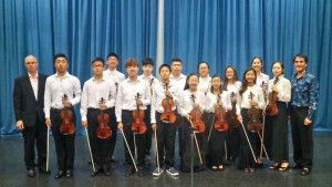 Members of the Doremi Music School group “String Stars” pose for a picture with pianist Cameron Fruit, front, leftmost, and instructor Ao Zhang, front, far right. (Contributed Photo)