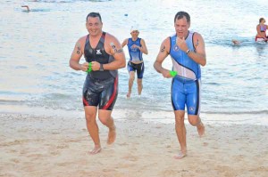 Brad Ruszala, left, and Russ Quinn, right head to the swim-bike transition area at the Pacific Islands Club during last year’s Tagaman Triathlon. This year’s Tagaman will start in the waters off Kanoa Resort.  (Roselyn B. Monroyo)