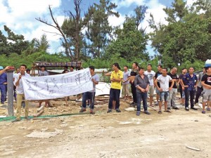 MCC International workers protest with signs while chanting “MCC pay us!” The workers have refused to work for two weeks and demand to be paid their wages from February to April before being sent home at the expense of MCC. (Erwin Encinares)