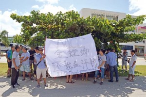 Construction workers of Gold Mantis Construction hold a protest rally yesterday near the Garapan Basketball Court. Although the banner in the photo says “MCC,” the Chinese characters written under MCC literally translates to Gold Mantis. The relationship between MCC and Gold Mantis Construction is still unclear. (Erwin Encinares)