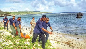 Department of Fire and Emergency Medical Services Search and Rescue Unit members carry the body of 60-year-old Japanese diver Norihiko Manabe, which they found floating along the shoreline at Laolao Bay yesterday afternoon. Manabe went swimming with a dive instructor and two other divers yesterday morning when he later could not be found. (DFEMS)
