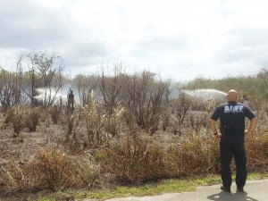 Firefighters from the Commonwealth Ports Authority’s Aircraft Rescue Firefighting try to extinguish a brush fire in As Gonno yesterday afternoon. As of press time, another wildfire was still raging in Talafofo. At least seven grass fires hit the CNMI in the past five days. (Ferdie de la Torre)