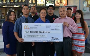 Marcia Ayuyu, owner/ operator of McDonald’s Saipan, center, and Joe Ayuyu Jr., general manager of McDonald’s of Saipan, second from left, present a $5,000 hole-in-one check to Ben Babauta, TOC tournament director. They are accompanied by a McDonald’s employees and TOC planning committee members. (Contributed Photo)