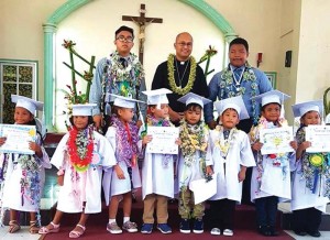 Junior high and Kindergarten graduates have their picture taken with the Most Rev. Ryan Jimenez, bishop of the Diocese of Chalan Kanoa. (Contributed Photo)