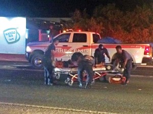 Department of Fire and Emergency Medical Services medics attend to a man who was injured after a car struck him as he was crossing Chalan Monsignor Guerrero Road in front of the MangoSix Restaurant in Dandan last Friday night. (Ferdie de la Torre)