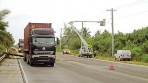 Commonwealth Utilities Corp. crewmembers fix the power line along Chalan Pale Arnold in Tanapag yesterday afternoon. A tractor-trailer with a 40-footer container of Best Sunshine accidentally dragged a Docomo cable wire, causing a telephone pole to fall and triggering a power outage in the area. (Ferdie de la Torre)