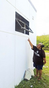 Youth Learning Center acting program coordinator Gloria Kaipat shows the shattered glass panel window at the boy’s restroom of the Koblerville Youth Learning Center. Three drunken school dropouts were tagged as suspects behind the vandalism that occurred last Sunday night. The suspects managed to run away to a jungle area behind the Center. (Ferdie de la Torre)