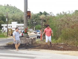 The mother of 19-year-old Soomin Jung wipes her tears as she and a friend walk away from the traffic light pole, where they placed flowers and offered prayers on Saturday shortly before noon. Jung’s vehicle slammed into the traffic light near the Northern Marianas College on Saturday at midnight and a fire ensued, trapping her inside. Jung was said to be coming from the hospital and was on her way to a friend’s house in As Lito when the accident happened. (Ferdie de la Torre)