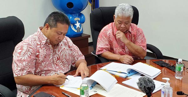 Torres signing the budget bill into Public Law 22-08 as Palacios looks
