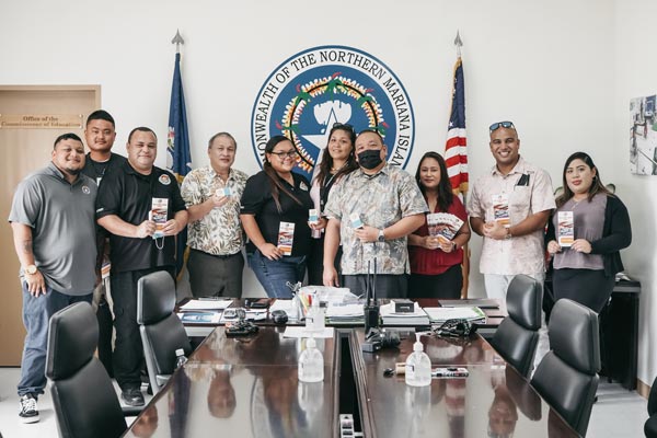 Commonwealth Office of Transit Authority employees and CNMI Public School System officials led by Board of Education chair Andrew L. Orsini, fourth from left, show off the 300 complimentary transit passes