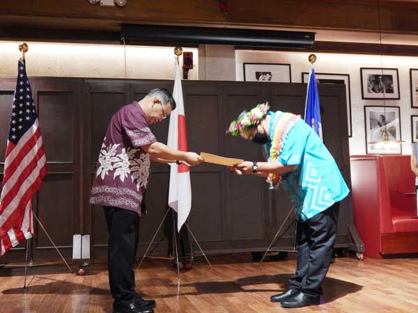 Gordon Ichihara Marciano, right, bows as he receives the Japan Foreign Minister