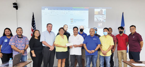 Check donation to Pacific Mini Games Organizing Committee chair Marco Peter, seventh left, during a brief ceremony at the conference room of the Gilbert C. Ada Gymnasium
