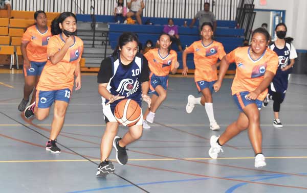 Saipan Community School’s Hilah Bacani dribbles away from the defense of Tanapag Middle School players .