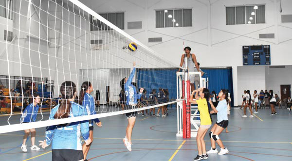 Saipan International School 2 player spikes the ball over the net against Marianas High School 2