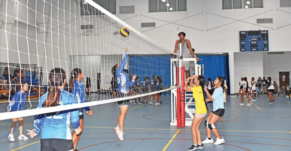 Saipan International School 2 player spikes the ball over the net against Marianas High School 2