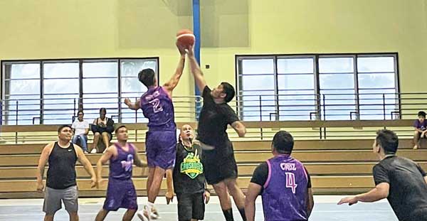 Team Kio’s Robert Reyes, left, and Team CNMI’s Estevan Borja jump it off in center court