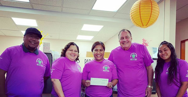 Haggan/Woong United for Recovery program manager Herbert J. Sablan, president Wilma Villanueva, director TaAnn Kabua-Demapan, treasurer Dr. Nelson Krum, and secretary Queayla Sablan share a photo holding up the $25,000 check