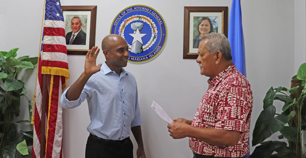 Attorney General Edward Manibusan, right, swears in Chester Hinds as the new chief prosecutor