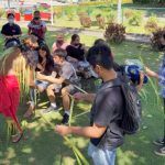 Troy Laniyo, left, demonstrates coconut frond weaving to students of Marianas Youth Welcome All Visitors Enthusiastically clubs of KHS