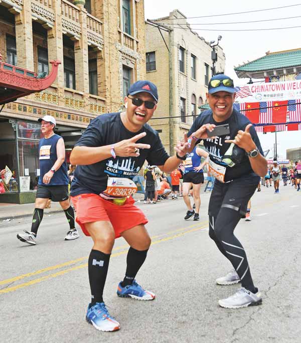 Diocese of Chalan Kanoa Bishop Ryan Jimenez and his social media specialist Rommel Buenaflor are all smiles after completing the 2021 Bank of America Chicago Marathon