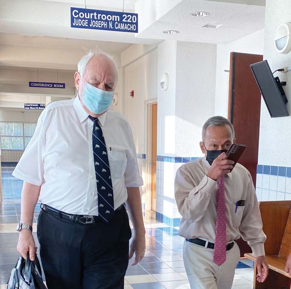 Rep. Vicente Camacho (D-Saipan), right, exits a Superior Court courtroom following a hearing