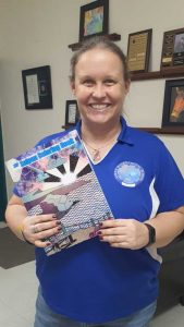 SIS art teacher Amie McRoberts poses with The Saipan Coloring Book.