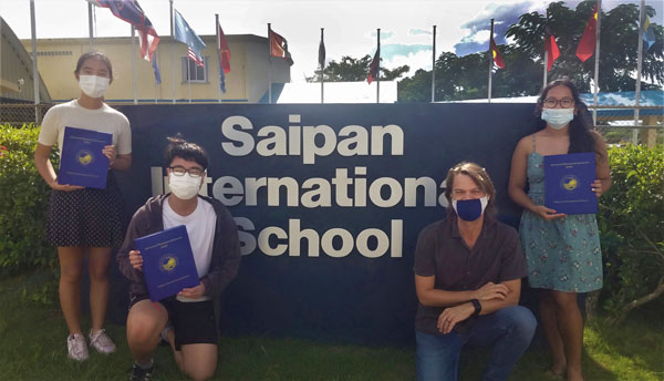 Cevina Hwang, Hyeonbin Jeong, SIS teacher Whitney Altizer, and Juliane Hall pose with their AP Research Books.