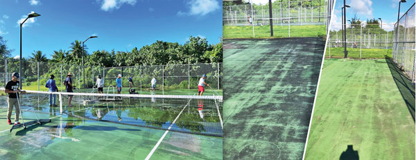 Volunteers clean one of the four tennis courts at the American Memorial Park