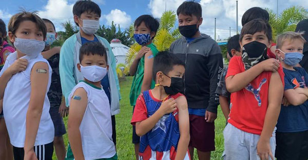 Young students of Saipan International School show off their bandages after being vaccinated against COVID-19. 